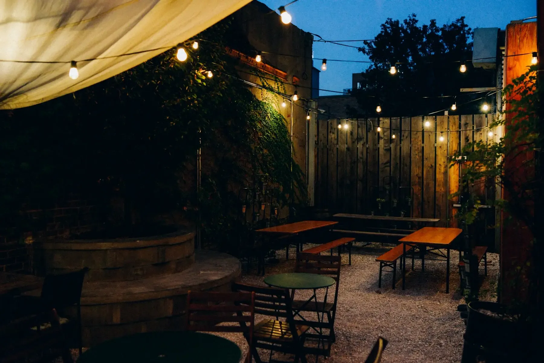 Outdoor seating area at dusk under string lights